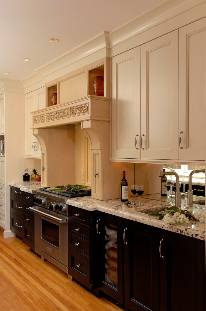 Example of a mid-sized classic galley medium tone wood floor eat-in kitchen design in DC Metro with an undermount sink, beaded inset cabinets, beige cabinets, granite countertops, beige backsplash, stone slab backsplash, stainless steel appliances and no island