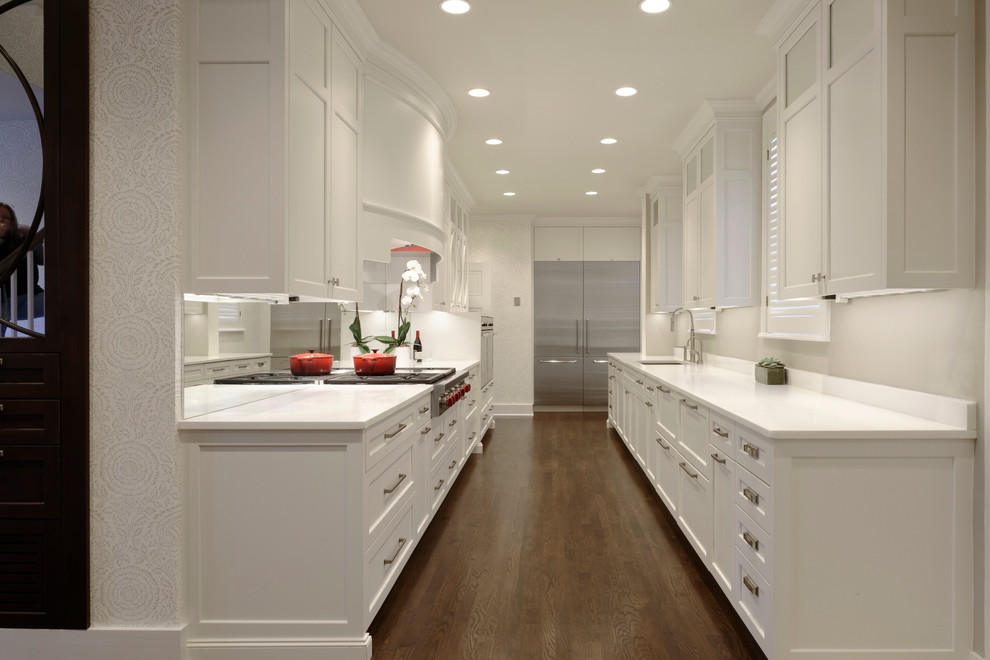 Exempel på ett mellanstort klassiskt kök, med en undermonterad diskho, luckor med profilerade fronter, vita skåp, grått stänkskydd, spegel som stänkskydd, rostfria vitvaror, mellanmörkt trägolv och bänkskiva i kvartsit
