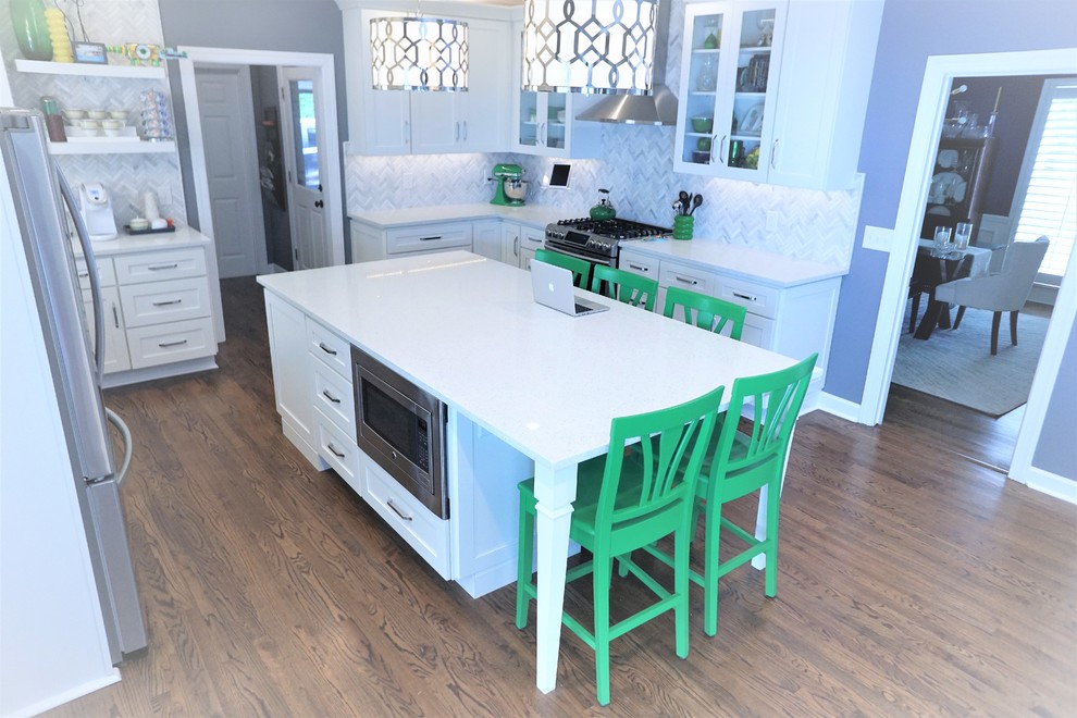 Mid-sized transitional u-shaped medium tone wood floor and brown floor enclosed kitchen photo in Jacksonville with an undermount sink, flat-panel cabinets, white cabinets, quartz countertops, white backsplash, marble backsplash, stainless steel appliances, an island and white countertops