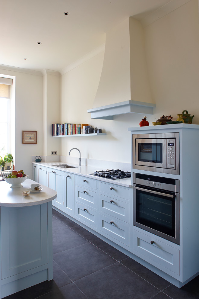 Zweizeilige, Mittelgroße Landhaus Wohnküche mit Einbauwaschbecken, Schrankfronten im Shaker-Stil, blauen Schränken, Quarzit-Arbeitsplatte, Küchengeräten aus Edelstahl, Schieferboden und Kücheninsel in Surrey