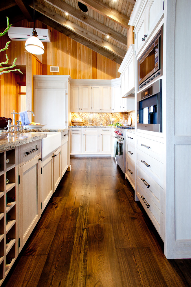Example of a large arts and crafts galley medium tone wood floor kitchen design in Toronto with a farmhouse sink, recessed-panel cabinets, white cabinets, granite countertops, paneled appliances and an island