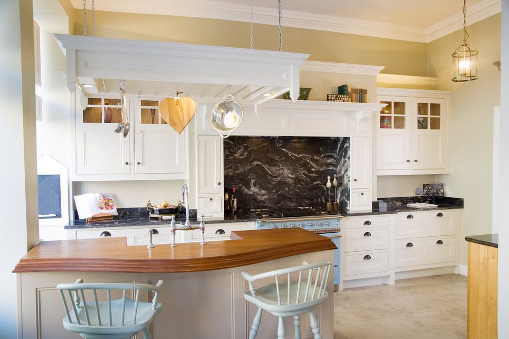 Immagine di un cucina con isola centrale classico con lavello stile country, top in granito, paraspruzzi nero, paraspruzzi in lastra di pietra e elettrodomestici colorati