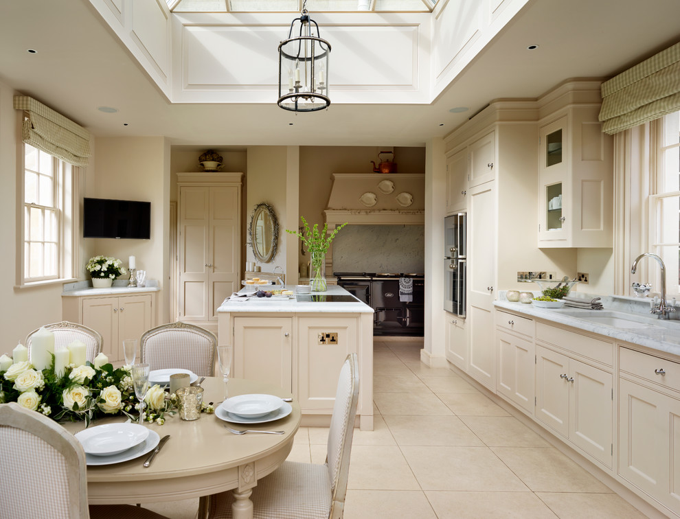 Foto de cocina clásica grande con armarios con rebordes decorativos, encimera de mármol, salpicadero verde, electrodomésticos de acero inoxidable y una isla