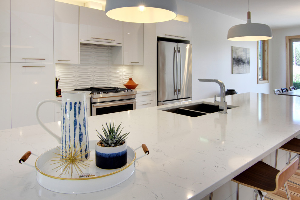 Exempel på ett mellanstort modernt vit linjärt vitt kök och matrum, med en dubbel diskho, släta luckor, vita skåp, marmorbänkskiva, vitt stänkskydd, stänkskydd i porslinskakel, mellanmörkt trägolv, en köksö och brunt golv