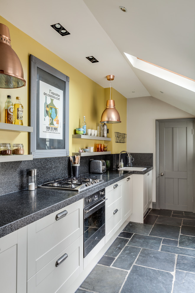 Klassische Küche mit Einbauwaschbecken, weißen Schränken, Küchengeräten aus Edelstahl und grauem Boden in Oxfordshire