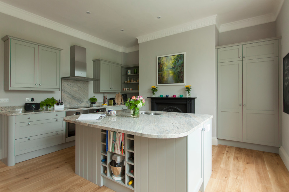 Photo of a traditional kitchen/diner in Other with a submerged sink, shaker cabinets, grey cabinets, granite worktops, stone slab splashback, stainless steel appliances, medium hardwood flooring and an island.