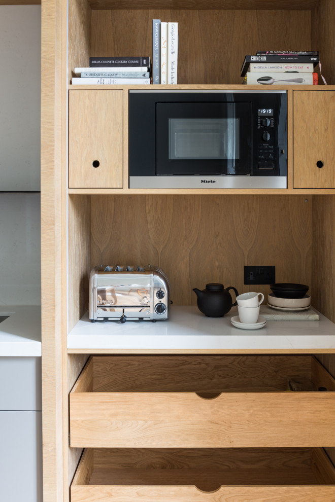Foto di una cucina contemporanea di medie dimensioni con ante lisce, top in quarzo composito e top bianco