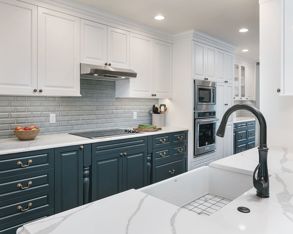 Mid-sized transitional galley light wood floor and brown floor eat-in kitchen photo in Portland with a farmhouse sink, raised-panel cabinets, blue cabinets, quartz countertops, blue backsplash, porcelain backsplash, stainless steel appliances, a peninsula and white countertops