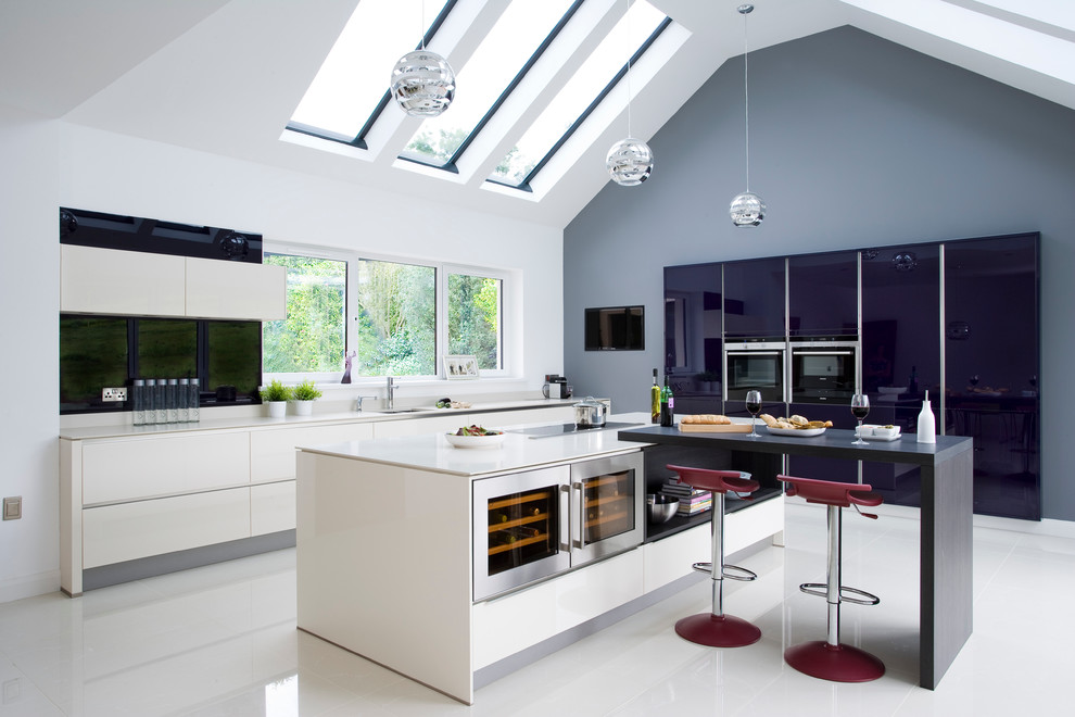 Geräumige Moderne Wohnküche in L-Form mit Unterbauwaschbecken, flächenbündigen Schrankfronten, blauen Schränken und Küchengeräten aus Edelstahl in Belfast