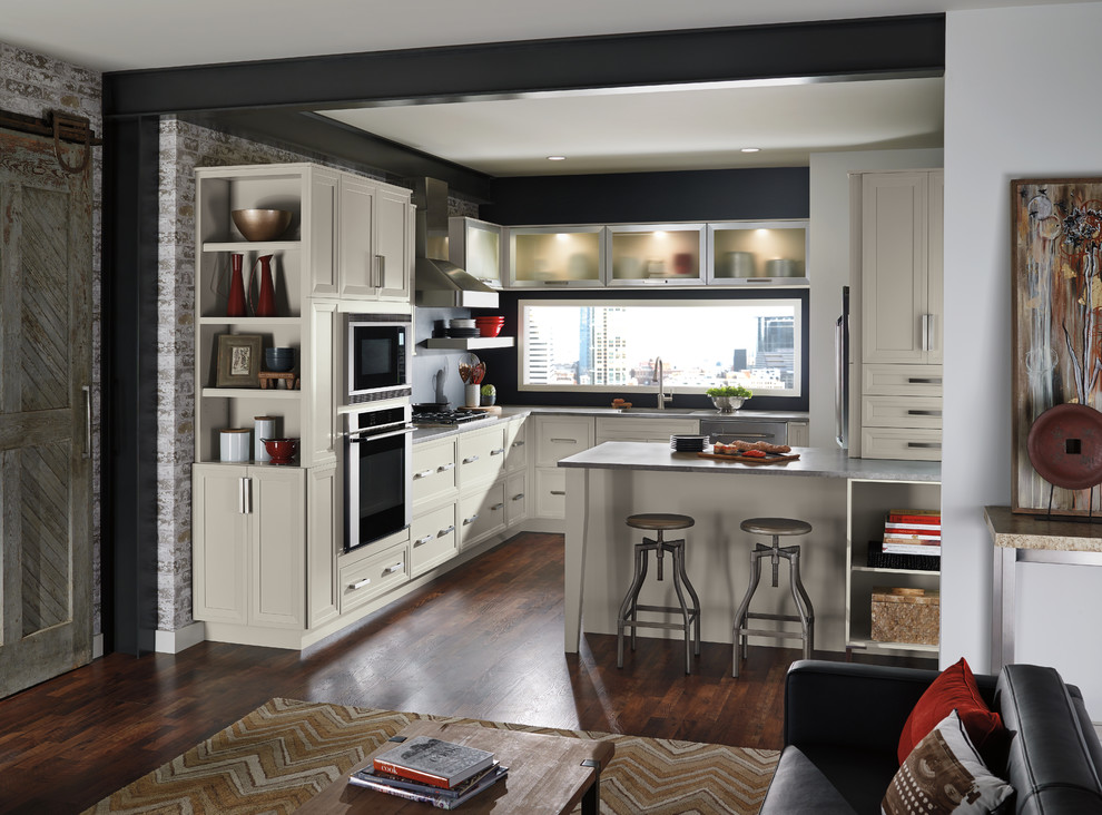 Inredning av ett klassiskt litet kök, med luckor med infälld panel, vita skåp, svart stänkskydd, rostfria vitvaror, mörkt trägolv, en undermonterad diskho, bänkskiva i zink och en halv köksö