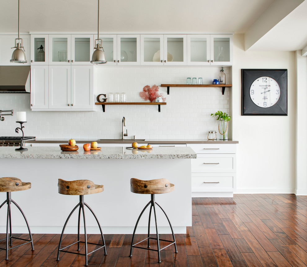 Example of a mid-sized beach style galley medium tone wood floor eat-in kitchen design in San Francisco with shaker cabinets, white cabinets, white backsplash, subway tile backsplash and an island