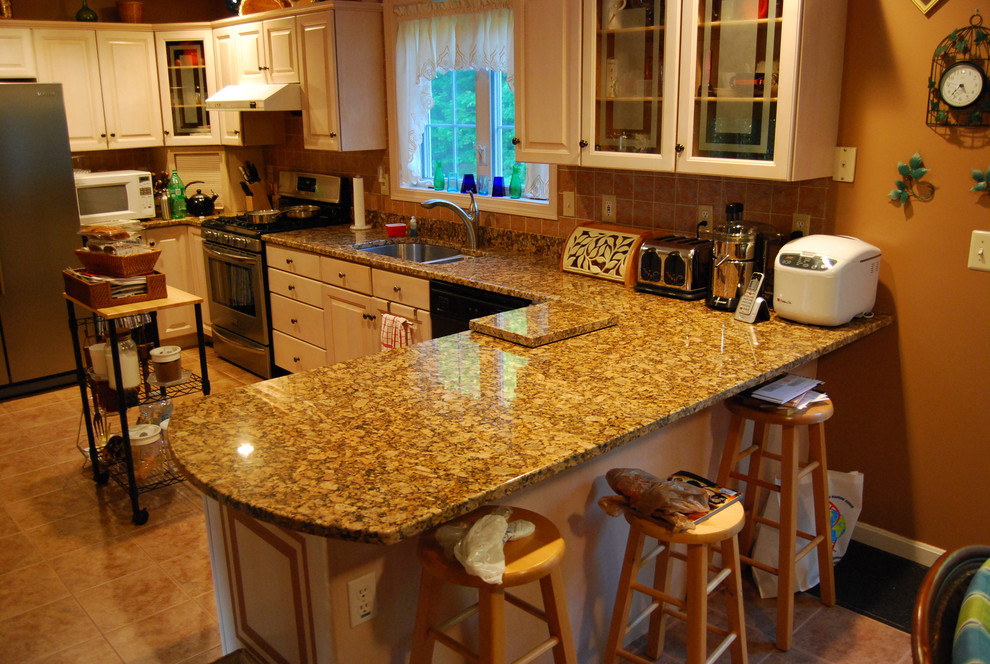 Example of a mid-sized classic u-shaped ceramic tile and brown floor eat-in kitchen design in Boston with an undermount sink, raised-panel cabinets, light wood cabinets, granite countertops, orange backsplash, terra-cotta backsplash, black appliances and an island