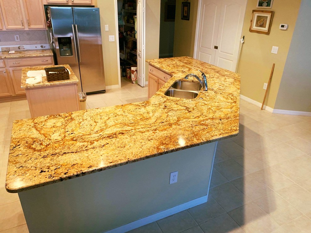 Example of a large minimalist l-shaped kitchen pantry design in Tampa with a double-bowl sink, granite countertops and an island