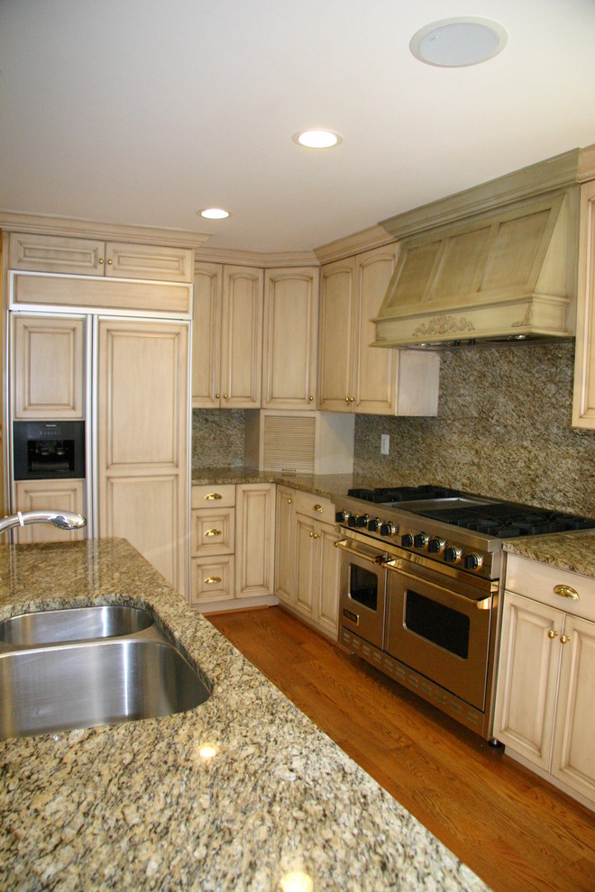 Immagine di una cucina abitabile tradizionale con lavello sottopiano, top in granito e elettrodomestici in acciaio inossidabile