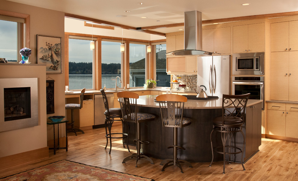 Inspiration for a mid-sized l-shaped light wood floor open concept kitchen remodel in Seattle with flat-panel cabinets, multicolored backsplash, stainless steel appliances, an island, a double-bowl sink, light wood cabinets, solid surface countertops and mosaic tile backsplash