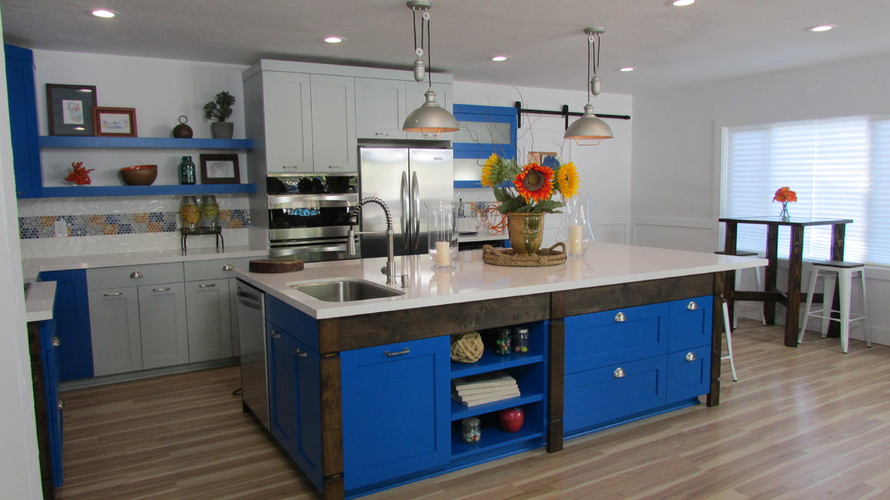 Example of a mid-sized transitional l-shaped light wood floor eat-in kitchen design in Sacramento with an undermount sink, shaker cabinets, gray cabinets, porcelain backsplash, stainless steel appliances and an island