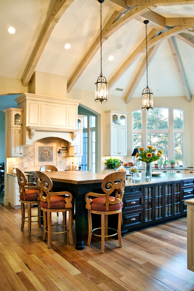 Elegant kitchen photo in Charleston with raised-panel cabinets and wood countertops