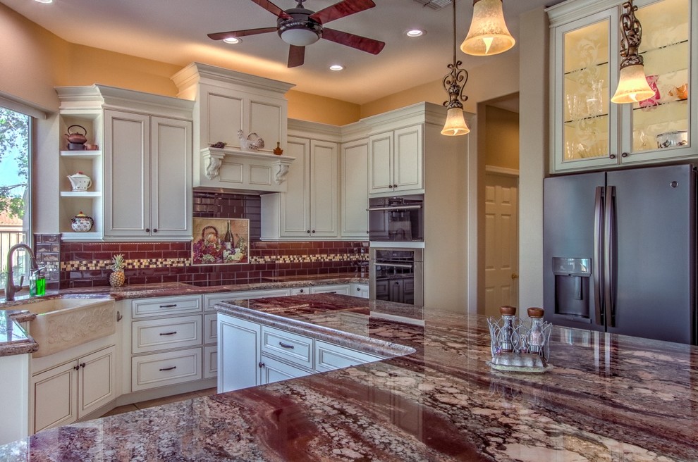Exempel på ett mellanstort modernt flerfärgad flerfärgat kök och matrum, med en rustik diskho, luckor med profilerade fronter, vita skåp, granitbänkskiva, rött stänkskydd, stänkskydd i tunnelbanekakel, rostfria vitvaror, klinkergolv i keramik, en köksö och beiget golv