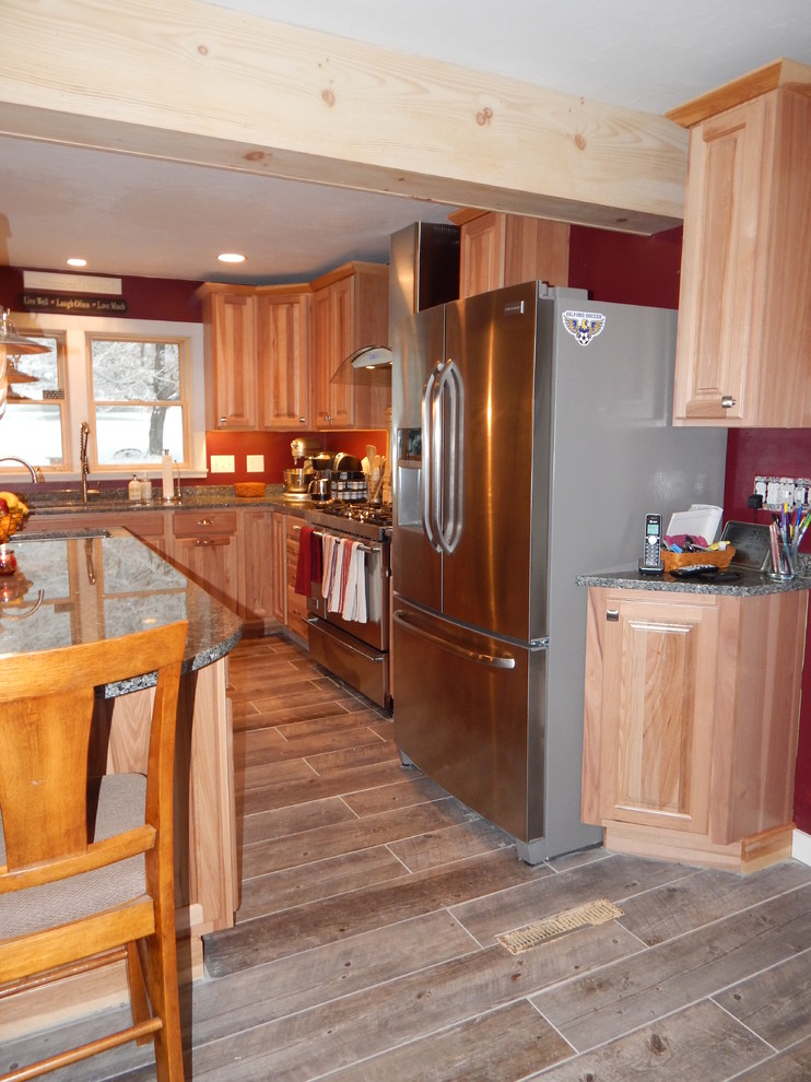 Bild på ett mellanstort vintage kök, med en enkel diskho, luckor med upphöjd panel, skåp i mellenmörkt trä, granitbänkskiva, flerfärgad stänkskydd, stänkskydd i tunnelbanekakel, rostfria vitvaror, klinkergolv i porslin och en köksö