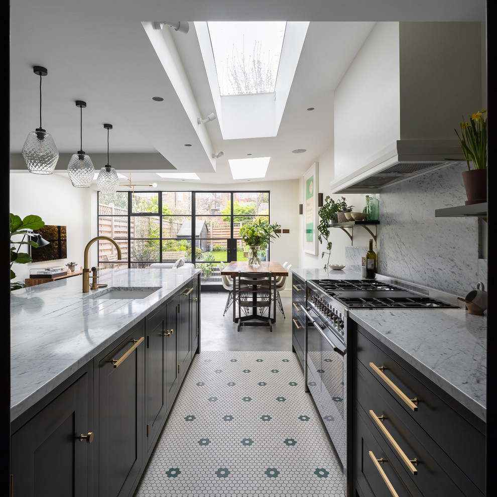 ロンドンにある高級な中くらいなコンテンポラリースタイルのおしゃれなキッチン (一体型シンク、シェーカースタイル扉のキャビネット、緑のキャビネット、大理石カウンター、白いキッチンパネル、大理石のキッチンパネル、シルバーの調理設備、磁器タイルの床、グレーの床、白いキッチンカウンター) の写真
