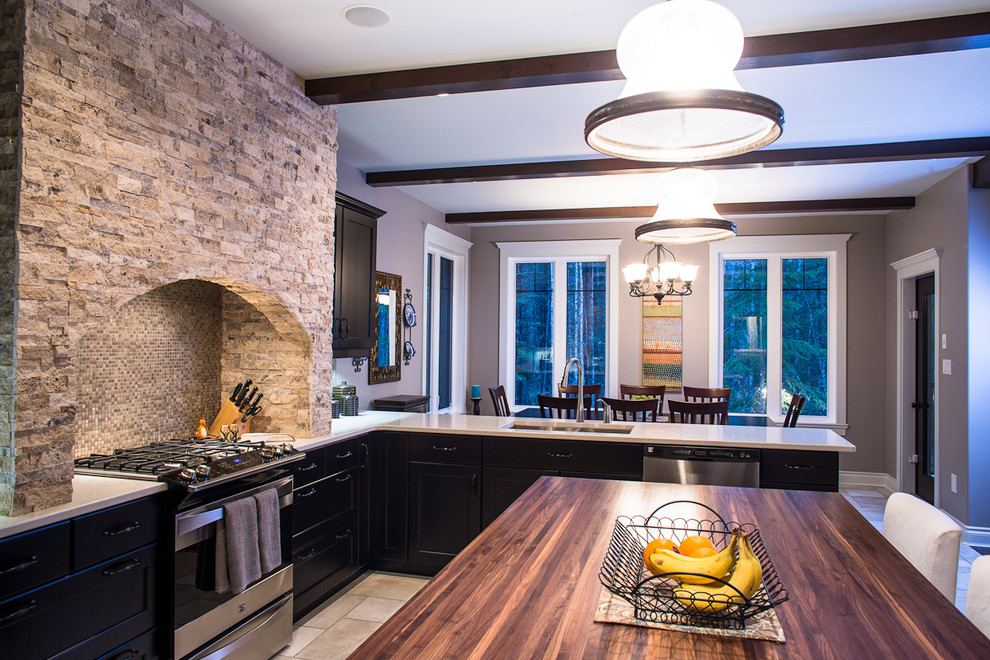 Bild på ett mellanstort medelhavsstil kök, med en undermonterad diskho, skåp i shakerstil, svarta skåp, träbänkskiva, beige stänkskydd, stänkskydd i mosaik, rostfria vitvaror, klinkergolv i porslin och en köksö