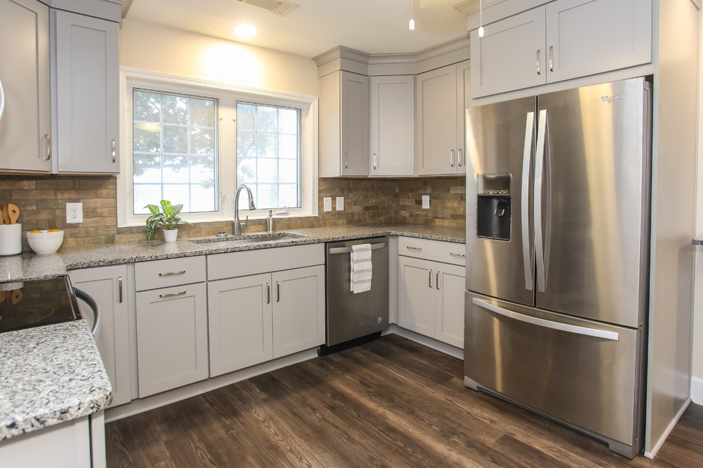 Exempel på ett mellanstort modernt flerfärgad flerfärgat kök, med en undermonterad diskho, skåp i shakerstil, grå skåp, granitbänkskiva, brunt stänkskydd, stänkskydd i keramik, rostfria vitvaror, vinylgolv och brunt golv