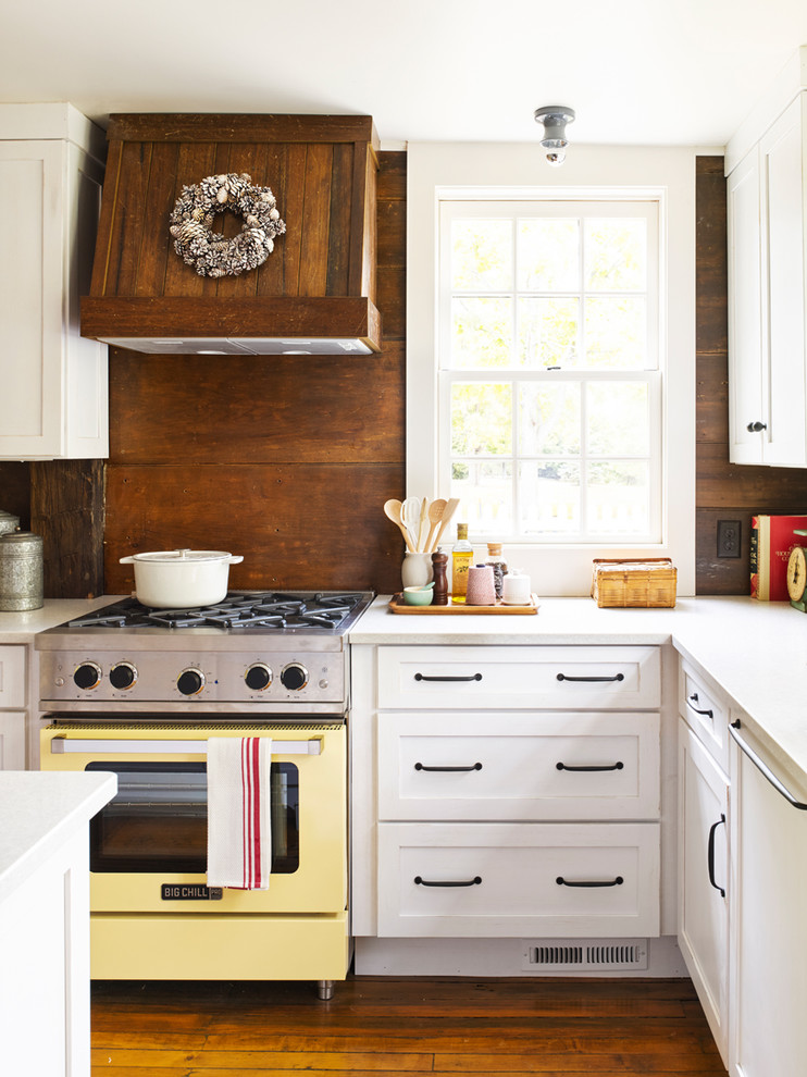 Inspiration for a farmhouse l-shaped kitchen in Cleveland with shaker cabinets, white cabinets, engineered stone countertops, coloured appliances, medium hardwood flooring and brown splashback.