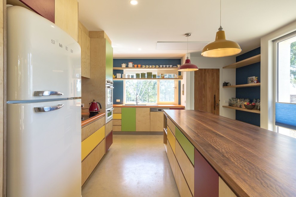 This is an example of a medium sized contemporary l-shaped kitchen/diner in Canberra - Queanbeyan with a double-bowl sink, flat-panel cabinets, light wood cabinets, an island, orange worktops, white appliances and beige floors.