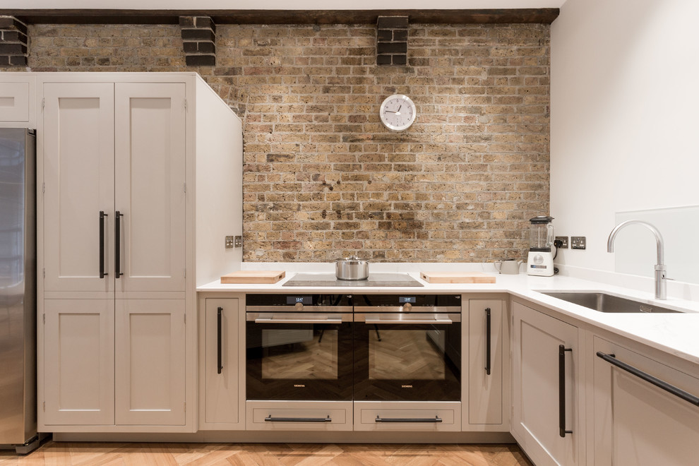 Example of a large trendy kitchen design in London with recessed-panel cabinets, beige cabinets, quartzite countertops and white countertops