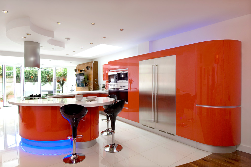 Open concept kitchen - large modern u-shaped porcelain tile open concept kitchen idea in London with an integrated sink, flat-panel cabinets, red cabinets, solid surface countertops, red backsplash, glass sheet backsplash, stainless steel appliances and a peninsula