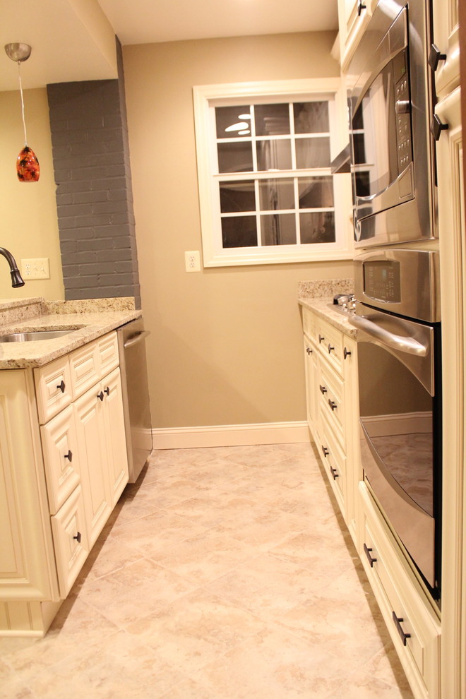 Example of a small classic galley enclosed kitchen design in Houston with a single-bowl sink, raised-panel cabinets, white cabinets, granite countertops, beige backsplash, ceramic backsplash, stainless steel appliances and a peninsula