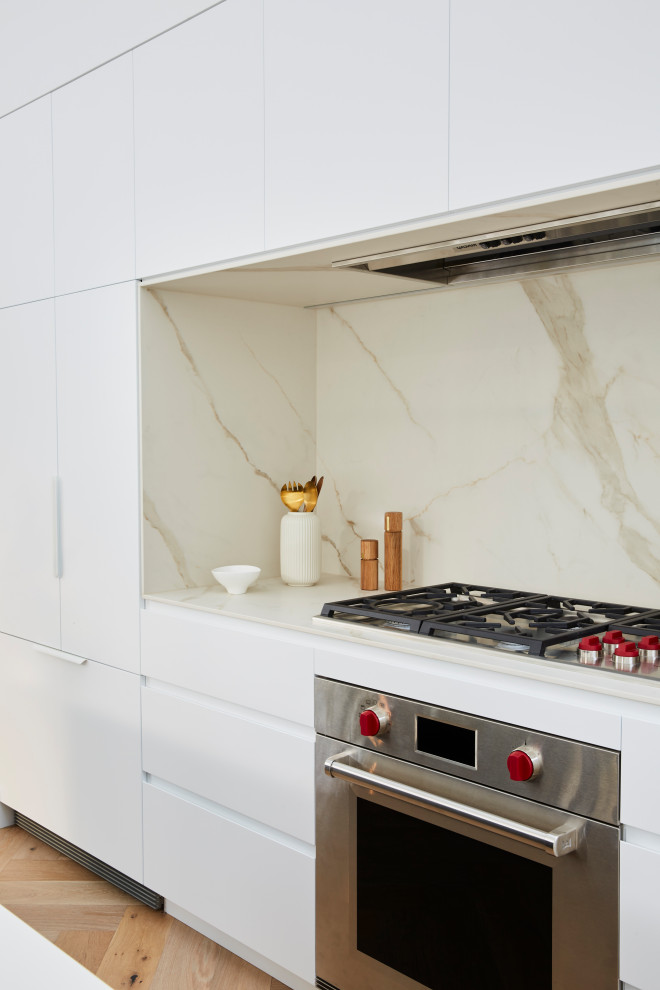 Photo of a scandi galley kitchen pantry in Sydney with a built-in sink, white cabinets, engineered stone countertops, beige splashback, marble splashback, an island, beige floors and white worktops.