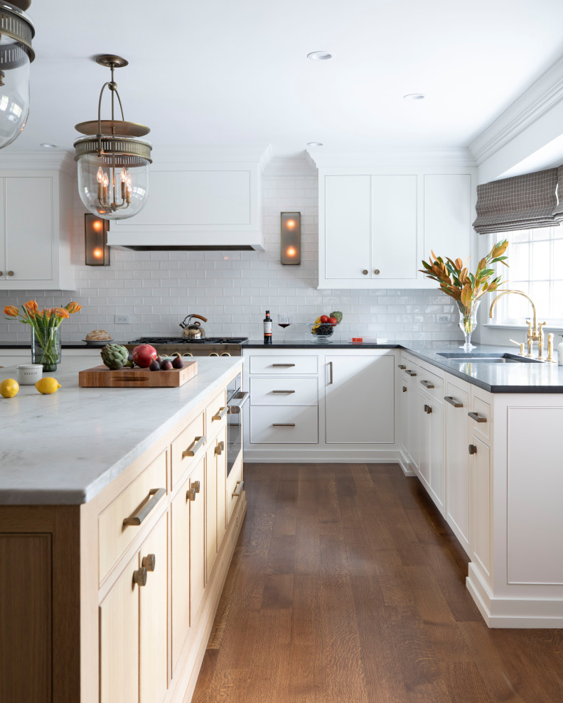Inspiration for a traditional l-shaped kitchen in Philadelphia with a submerged sink, white cabinets, white splashback, an island, black worktops and dark hardwood flooring.