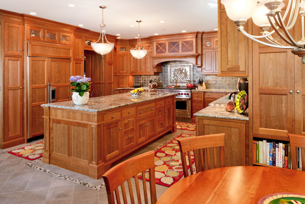Immagine di una cucina ad U classica con ante con riquadro incassato, ante in legno scuro, paraspruzzi marrone e elettrodomestici da incasso
