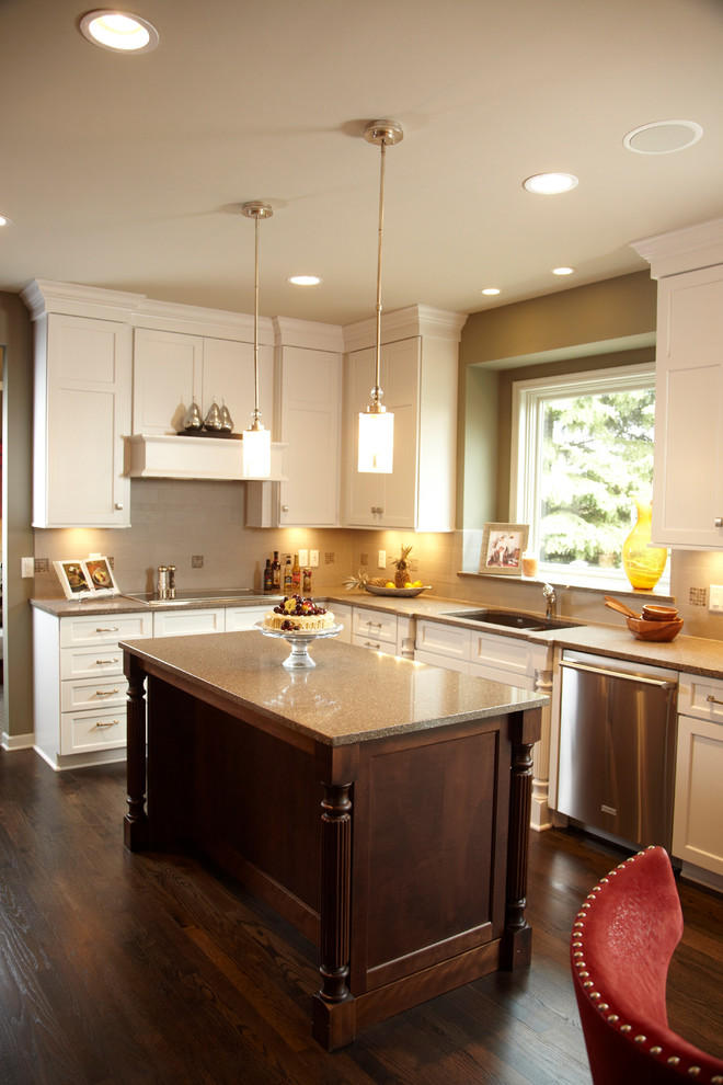Example of an arts and crafts l-shaped dark wood floor eat-in kitchen design in Minneapolis with shaker cabinets, white cabinets, beige backsplash, stainless steel appliances and an island