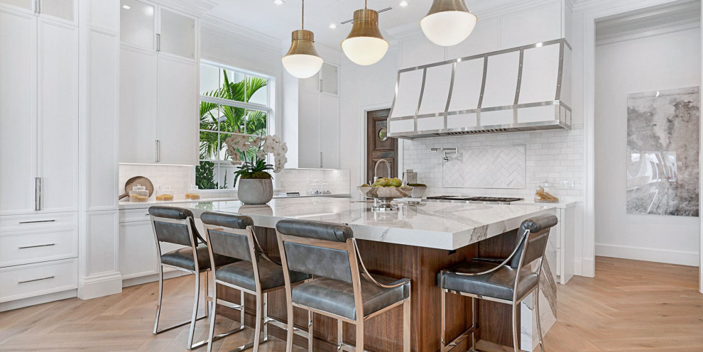 Offene Klassische Küche mit flächenbündigen Schrankfronten, Quarzwerkstein-Arbeitsplatte, Küchengeräten aus Edelstahl, Kücheninsel und weißer Arbeitsplatte in Miami