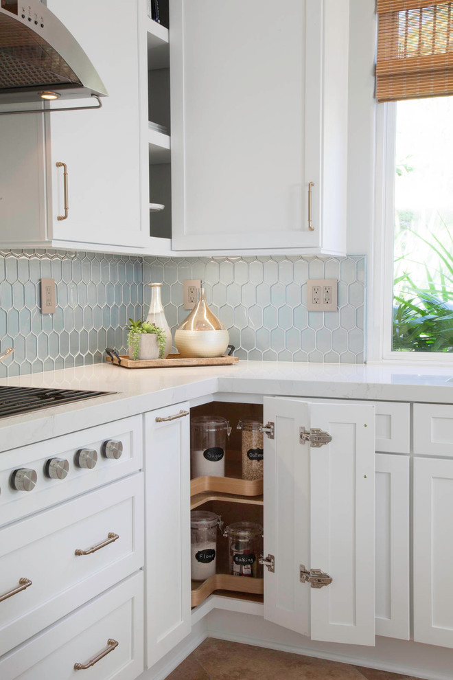 Exempel på ett mellanstort blå blått kök, med en undermonterad diskho, skåp i shakerstil, vita skåp, bänkskiva i kvartsit, blått stänkskydd, stänkskydd i glaskakel, rostfria vitvaror, travertin golv, en köksö och beiget golv