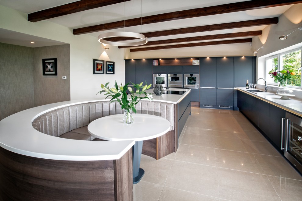 Immagine di un'ampia cucina contemporanea con ante lisce, ante blu, elettrodomestici in acciaio inossidabile, pavimento beige, top bianco, lavello sottopiano e paraspruzzi a finestra