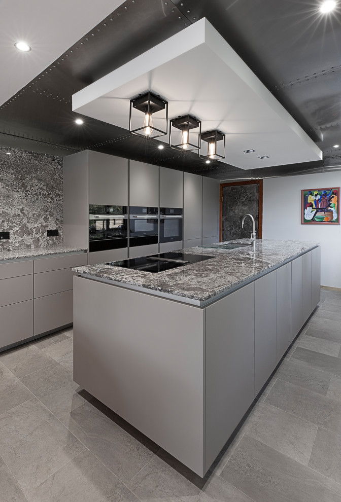 Idéer för mellanstora funkis flerfärgat kök, med en undermonterad diskho, släta luckor, grå skåp, granitbänkskiva, flerfärgad stänkskydd, svarta vitvaror, vinylgolv, en köksö och grått golv