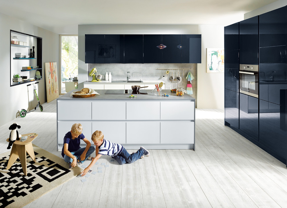 Ispirazione per una grande cucina moderna con ante lisce, ante blu, elettrodomestici in acciaio inossidabile e pavimento in legno verniciato