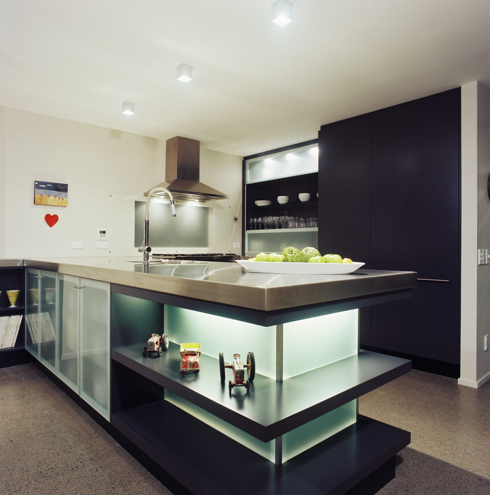 Photo of a medium sized contemporary u-shaped open plan kitchen in Los Angeles with an integrated sink, flat-panel cabinets, black cabinets, stainless steel worktops, window splashback, stainless steel appliances, concrete flooring and a breakfast bar.