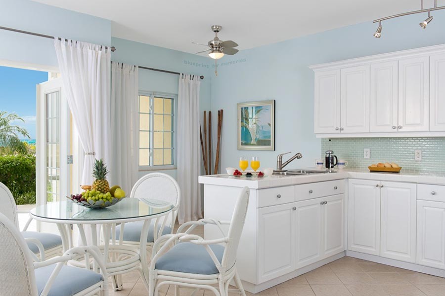 Foto de cocina exótica con fregadero de doble seno, puertas de armario blancas, salpicadero blanco y salpicadero de azulejos de vidrio