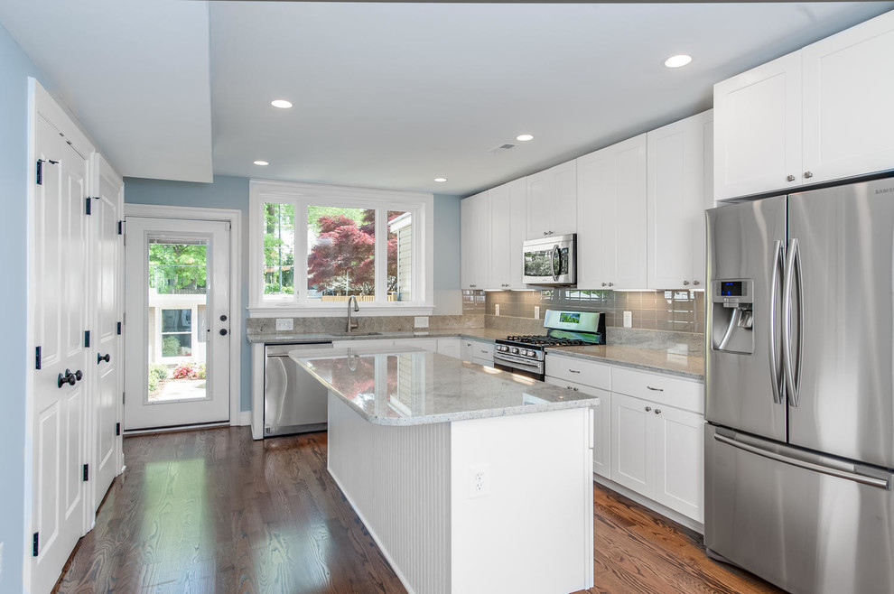 Trendy l-shaped eat-in kitchen photo in Other with white cabinets, gray backsplash, glass tile backsplash and stainless steel appliances