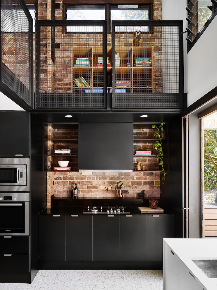 Example of a large urban l-shaped concrete floor kitchen pantry design in Sunshine Coast with an undermount sink, black cabinets, wood countertops, brick backsplash, stainless steel appliances and an island