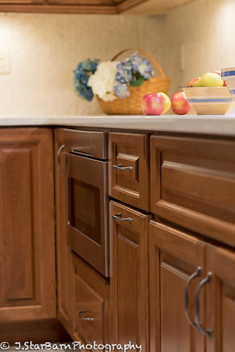 Bild på ett mellanstort vintage kök, med en undermonterad diskho, luckor med upphöjd panel, skåp i mellenmörkt trä, bänkskiva i kvartsit, beige stänkskydd, stänkskydd i keramik, rostfria vitvaror, klinkergolv i porslin och en köksö