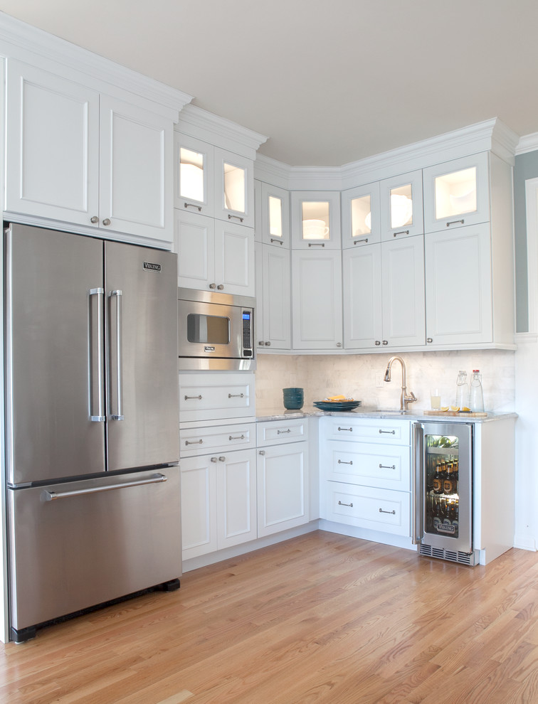 Idéer för att renovera ett mellanstort vintage kök, med en undermonterad diskho, luckor med infälld panel, vita skåp, granitbänkskiva, vitt stänkskydd, stänkskydd i stenkakel, rostfria vitvaror, mellanmörkt trägolv och en köksö