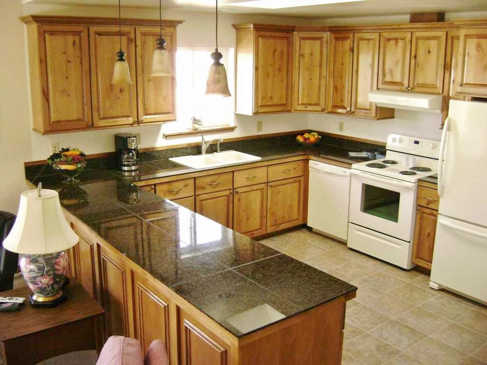 Foto de cocina tradicional con armarios con paneles con relieve, puertas de armario de madera clara, encimera de granito y electrodomésticos blancos