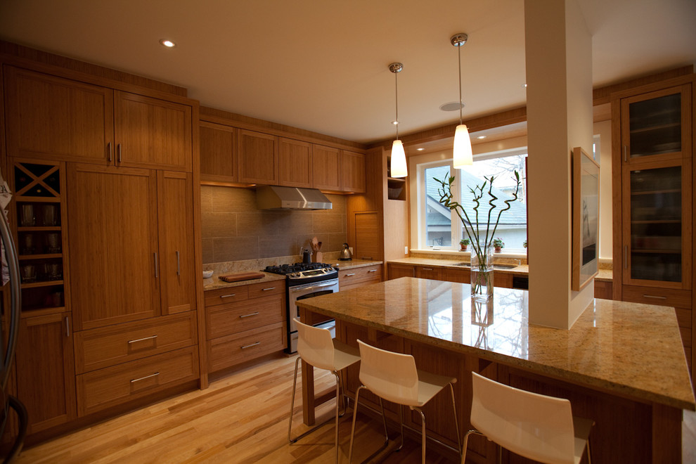 Photo of a large classic u-shaped kitchen/diner in Ottawa with a submerged sink, shaker cabinets, medium wood cabinets, granite worktops, brown splashback, porcelain splashback, stainless steel appliances, light hardwood flooring and an island.