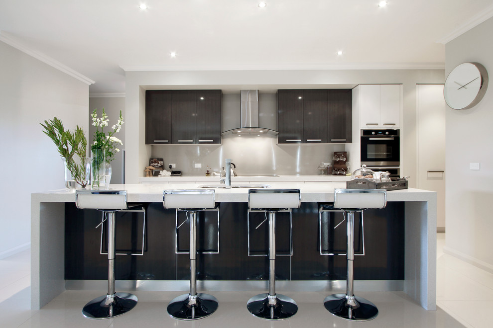 メルボルンにあるコンテンポラリースタイルのおしゃれなキッチン (黒いキャビネット、グレーのキッチンパネル、ガラス板のキッチンパネル、シルバーの調理設備、フラットパネル扉のキャビネット) の写真