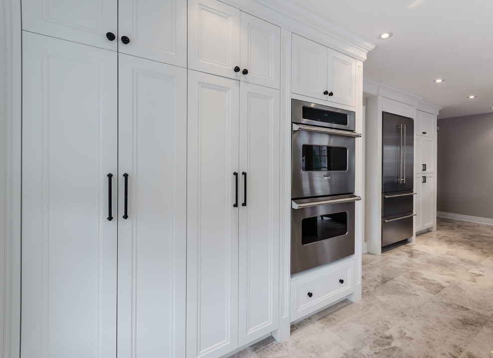 Kitchen pantry - mid-sized shabby-chic style galley travertine floor kitchen pantry idea in Toronto with recessed-panel cabinets, white cabinets, granite countertops, stainless steel appliances and an island